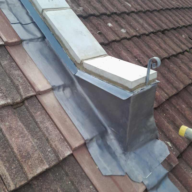 Lead valley flashing beside a parapet wall on a tiled roof in Portsmouth