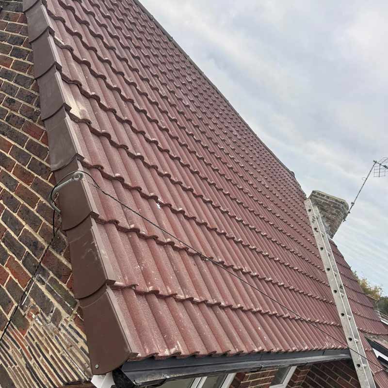New roof installation with red brown double Roman concrete tiles and dry verge system